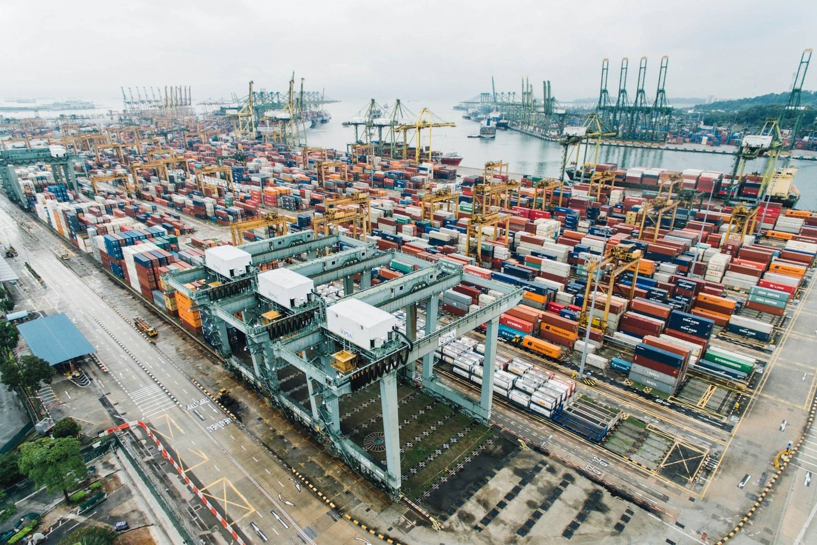 Container terminal seen from above, with cranes and stacked containers along the quay