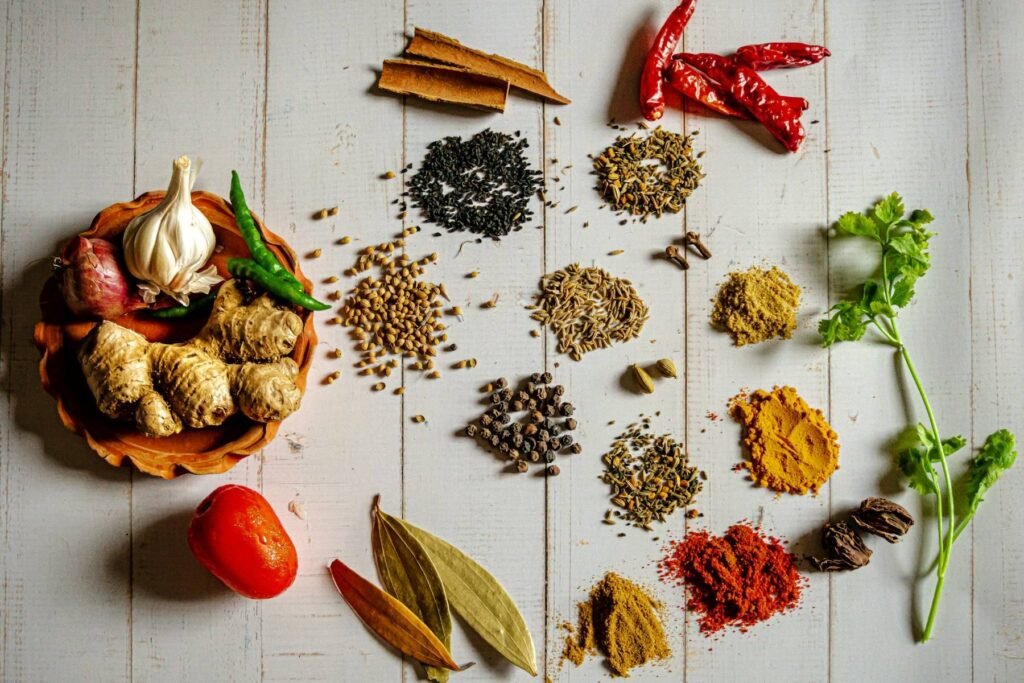 Whole and ground spices laid out on white boards: chillies, cinnamon, turmeric and peppercorns