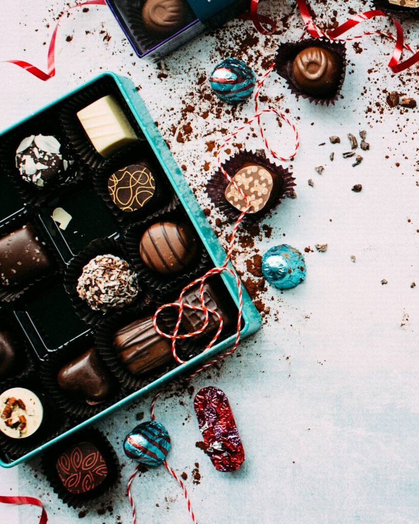 An open box of assorted pralines on a pale marble table